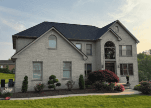 Large two-story house with new dark gray roof and landscaped front yard in North Huntingdon, Pennsylvania.