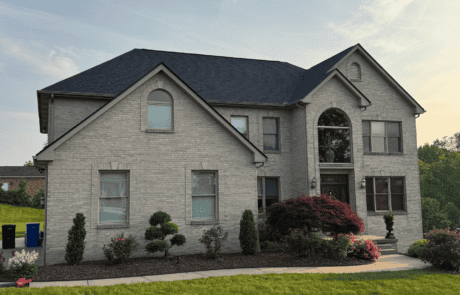 Large two-story house with new dark gray roof and landscaped front yard in North Huntingdon, Pennsylvania.