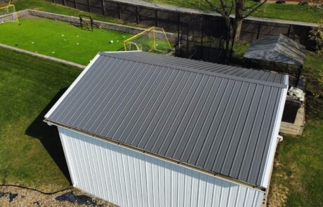 dji_fly_20250414_164728_560_1745076589083_photo_optimized (1) Metal roof installation on a small white shed in a backyard.